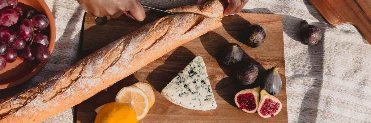 A baguette, blue cheese, lemon, figs on a chopping board